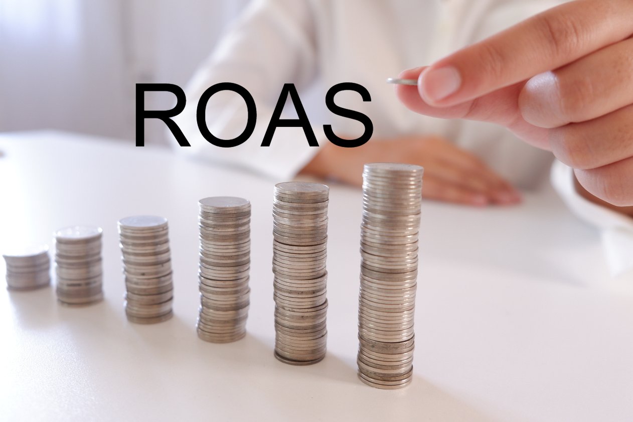 tangan seseorang sedang meletakkan koin yang mengilustrasikan pertumbuhan ROAS